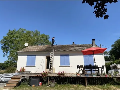 Nettoyage d'un pan de toiture sur une maison de plain-pied